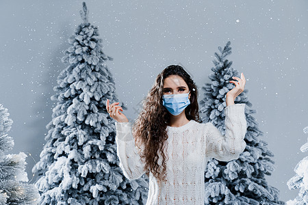 covid19冠状病毒检疫期的新年庆祝活动 戴着医用面具 飘着雪花的快乐女孩呆在家里 社交距离 在下雪天的寒假天气帽子季节生活衣图片