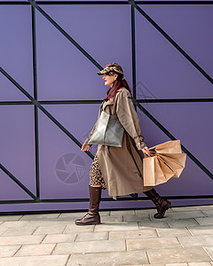 一个快乐的购物狂女孩把她的包放在购物中心附近 商店附近的一位女士拿着袋子对她购买的商品很满意 穿着豹纹连衣裙 消费观念姿势购物者图片