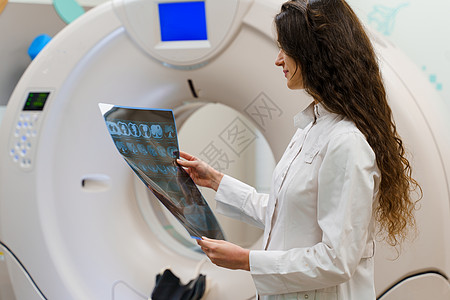 医科学生在附近看病人大脑X光照片 诊所的年轻女孩获得了新的经验图片