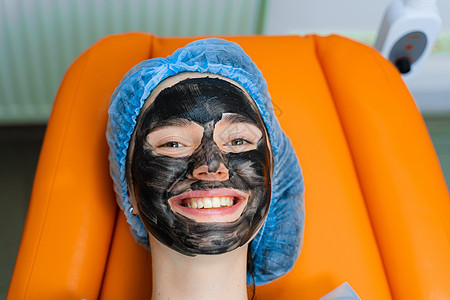 使用外科激光 用黑面罩遮住女孩脸部的碳剥皮 皮肤学和美容学胶原治疗皮肤表皮女性色素沉着化妆品程序毛孔护理图片
