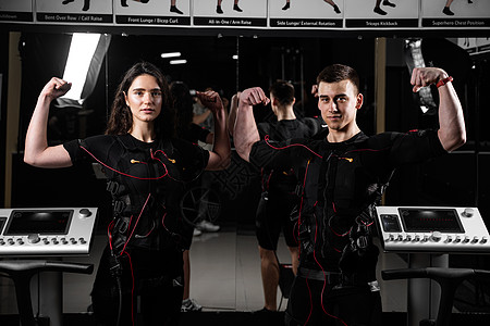 穿防弹背心的男男女女肩并肩微笑 在健身房有2名训练员锻炼训练女士幸福重量生活接触器药品爱好刺激图片