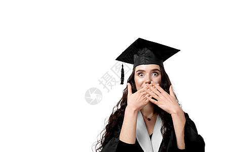 穿着毕业长袍和白底帽的单身女孩大吃一惊 快乐而有趣的年轻女子微笑 学生在单性中获得硕士学位教育野心女性职业毕业典礼学习大学成人成图片