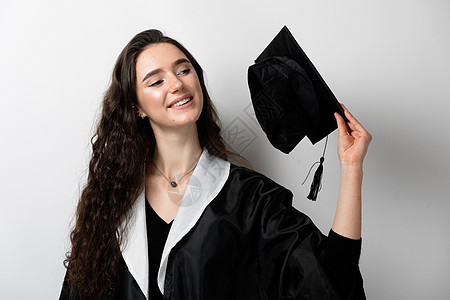 拥有黑色毕业礼服和白色背景帽子的硕士学位的女研究生 在线远程学习 在家学习 大学毕业成功成就者学生工作微笑教育女性学士野心院士图片