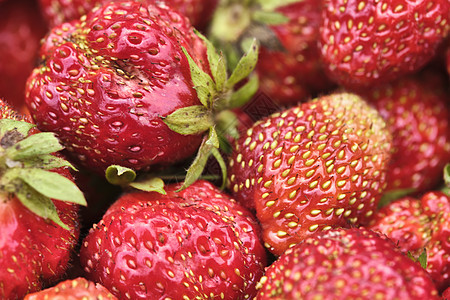 新鲜红草莓和叶子的特写细节 彩色自然图片