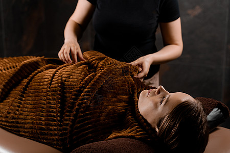 腰部按摩巧克力按摩美容治疗后 在温泉疗养所为女性模特提供全体温暖的毯子包扎病人程序奶油休息腹部皮肤美容院护理腰部沙龙背景