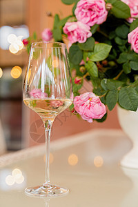 在光桌白花瓶的花朵背景上 杯白葡萄酒 彩虹玫瑰粉色庆典餐厅反射花束白色桌子服务酒精咖啡店图片
