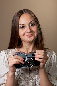 穿着漂亮裙子的年轻棕色头发女人 拿着反光照相机女性女孩女士青年工作室黑发发型微笑衣服摄影图片