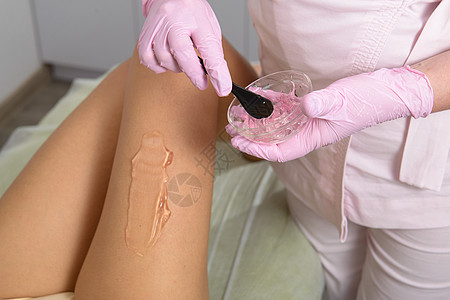 女美容师在女性的腿上应用接触凝胶 以便在诊所进行激光理发手术治疗技术医生卫生剃须化妆品沙龙药品护理女士图片