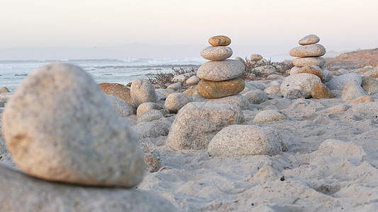 岩石平衡在石子海滩上 金字塔堆积的石头 海洋海岸 海水飞溅日落海滩岩石卵石波浪气氛冥想平衡支撑图片
