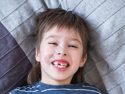 笑孩子嘴里长着一排牙齿的洞 刚才有个门牙掉了出来 给牙医贴上口香糖的照片喜悦童年牙龈嘴唇牙科学磨牙笑声卫生宏观乐趣图片