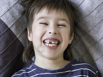 笑孩子嘴里长着一排牙齿的洞 刚才有个门牙掉了出来 给牙医贴上口香糖的照片笑声宏观口腔科矫正嘴唇生长童年男生磨牙展示图片