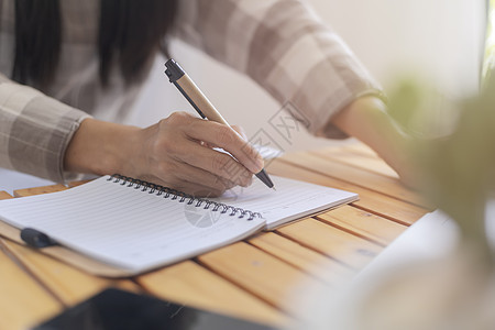 特写商业女性的手使用笔写文档纸 女性手在白纸上用蓝色钢笔写字 女人在一张纸上写信息桌子经理笔记学习女士合同签名人士教育办公室图片