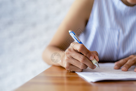 特写商业女性的手使用笔写文档纸 女性手在白纸上用蓝色钢笔写字 女人在一张纸上写信息阅读协议经理学生文书学习教育工作女士床单图片