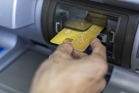 机器手使用自动取款机 用信用卡特写女性的手 使用他的信用卡的 atm 机的妇女 手持信用卡插入 ATM 卡槽机器提款银行业交易女士出纳背景