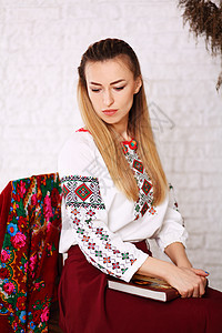 身着民族风格刺绣衬衫的年轻金发美女 来自乌克兰传统Vyshyvanka的现代衍生品靴子微笑红色小麦国家森林衣服文化衬裙裙子图片