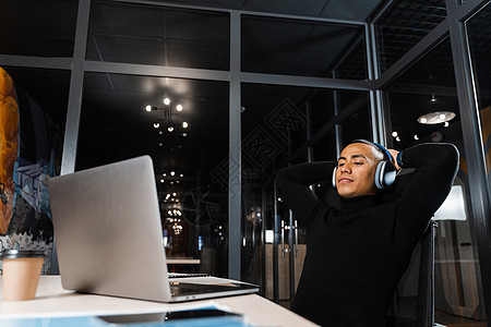 沉睡和疲倦的亚洲男子在办公室用笔记本电脑加班 休息图片