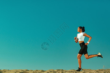 运动的年轻女子和健康的运动员赛跑者在天空背景下奔跑 健康的生活方式和运动的概念 黑色和白色运动服的女人女士女孩健身房训练速度竞赛图片