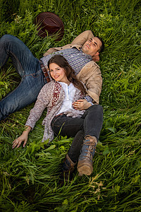 年轻夫妇在阳光明媚的白天在草地野餐 男人和女人享受彼此的陪伴图片