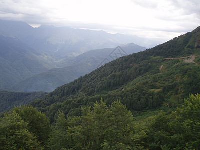 绿色优美风景一片全景的山地景观 其山谷和森林山峰在高覆云天下地平线场景旅游木头假期冒险场地远足山脉顶峰背景