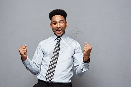 商业概念自信的年轻非裔美国人在空中挥拳庆祝成功项目 掌声工作室男人工作精力成就手势拳头庆典经理胜利图片