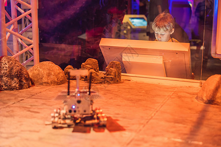男孩控制着火星上的玩具漫游 飞到火星的概念图片