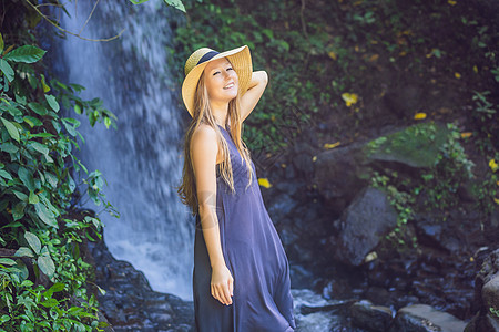 以瀑布背景为背景的女旅行者热带女孩背包国家森林冒险女性天堂女士自由图片
