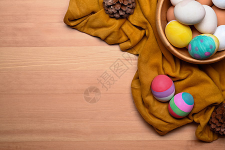 上方的复活节篮子 上面满是漆着复活节鸡蛋 在木制背景之上图片