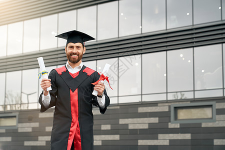 具有硕士学位地位的学生 持有两份文凭 微笑着笑容图片