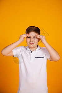 一个头痛的男孩 患有头痛和偏头痛的黄色背景的白人儿童青少年流感教育症状伤害痛苦男人前额焦虑学习图片