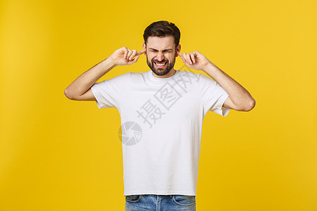穿着蓝衬衫的疯狂青年胡须男子 在工作室中以黄色橙色背景与世隔绝 人们生活方式概念 模拟空间复制头发耳朵压力男人情感男生手势蓝色衬图片