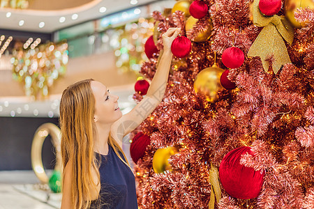 圣诞节老人女人挂着红圣诞树的装饰 红圣诞树挂在灯光的背景上背景