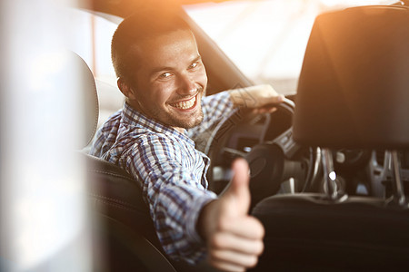 现代人坐在车里 举起拇指奢华交通窗户手势男性车辆商业商务座位旅行图片