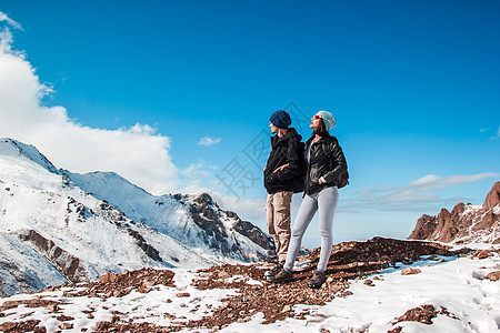 一个男人和一个女孩站在山坡上 在蓝天的背景下 蓝色的天空图片