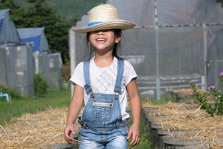 戴着帽子的小女孩在花园里帮助她的母亲 一个小园丁 可爱的小女孩在菜园里玩耍植物孩子生活女儿小学生教育学习园艺蔬菜环境图片