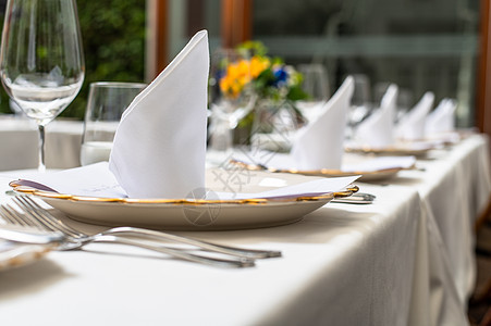 优雅的婚礼午餐桌 装饰着水晶杯子和黄色花朵庆典环境婚姻盘子用餐高脚杯刀具餐巾派对风格图片
