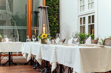 优雅的婚礼午餐桌 装饰着水晶杯子和黄色花朵婚姻餐厅刀具蜡烛椅子庆典接待服务玻璃桌布图片