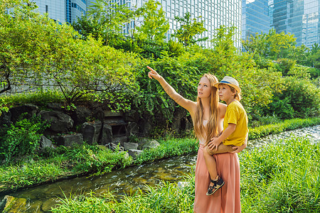 在韩国首尔的溪流中 母亲和儿子旅游者潮流是大规模城市改造项目的结果 前往韩国概念组织景观旅游背包目的地基础设施展示游客运河妈妈地图片
