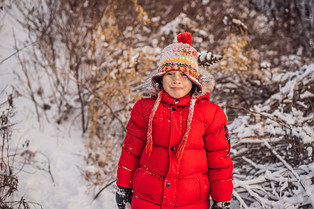 穿着红色时装的男孩在户外玩耍 在寒冷的日子里 在冬天与孩子们一起积极休闲 男孩玩第一场雪 快乐的小孩在雪地里玩耍 冬天天气很好童图片