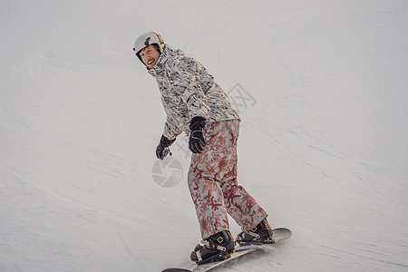 冬季在滑雪度假胜地的男性滑雪车单板男生森林运动装飞跃天空活动青少年娱乐闲暇图片