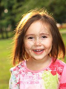 夏日在草地上的可爱小女孩太阳快乐头发微笑女士后代公园植物乐趣幸福图片