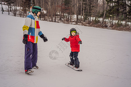 单板滑雪教练教男孩滑雪 冬季儿童活动 儿童冬季运动 生活方式空气娱乐木板头盔乐趣青少年家庭爸爸男生讲师背景