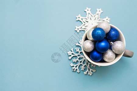 蓝色和银色的圣诞球在杯中 蓝背景 创意的概念是圣诞节和新年图片