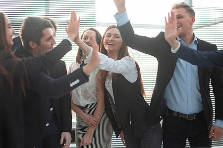 欢快的商业团队坐在办公室里做高五胜利职场合作公司伙伴庆典会议团体快乐手势图片