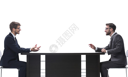 两个商界人士讨论坐在桌边的 东西 并讨论顾问讲话面试合同同事项目工作会议桌子男人图片