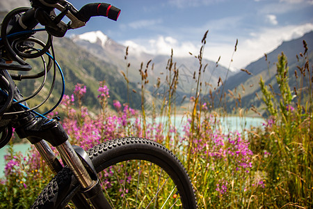 紧贴在山脚踏车前面 在山湖的模糊背景上图片