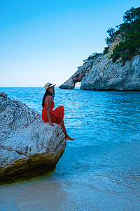 月水意大利撒丁岛海滩上的亚洲女性 意大利撒丁岛度假的年轻女孩 在清澈湛蓝的海水中玩耍的女人海岸线海景泳装晴天假期天线女士蜜月海岸天堂背景