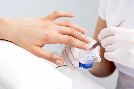 涂指甲油人手在女性指甲上涂清清漆卫生美容治疗绘画程序保健顾客诊所实验室技术背景