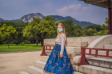 身着韩服韩服 戴着医用面具的年轻白人女游客 韩国旅游概念 韩国民族服装 游客娱乐——试穿韩国民族服装游客担心 2019-ncov图片