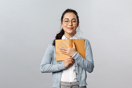 教育 教师 大学和学校的概念 浪漫梦幻可爱的女性闭上眼睛拥抱 带着乐观的微笑把日记紧紧地压在胸前 快乐地写下她的初吻混血闲暇学习图片