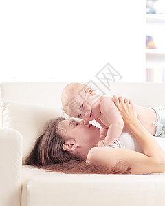 快乐的母亲和可爱的婴儿玩耍 有影印空间的照片图片